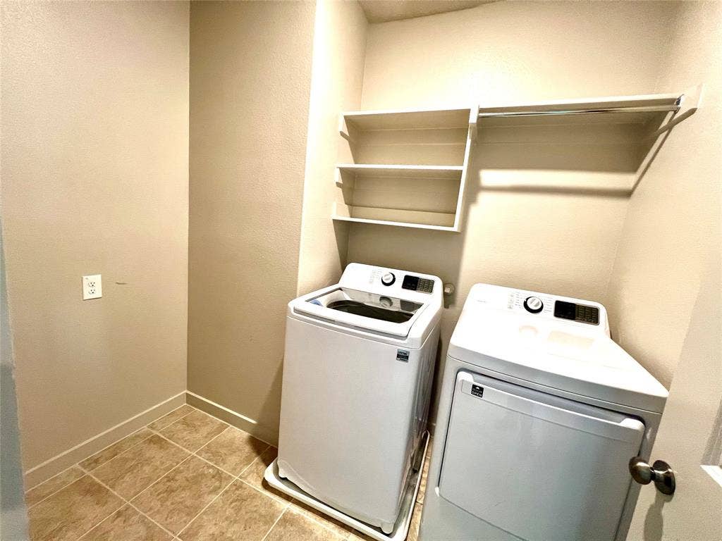 1755 Montgomery Drive, Plano, TX 75075 Clothes washing area with washing machine and dryer and light tile patterned floors