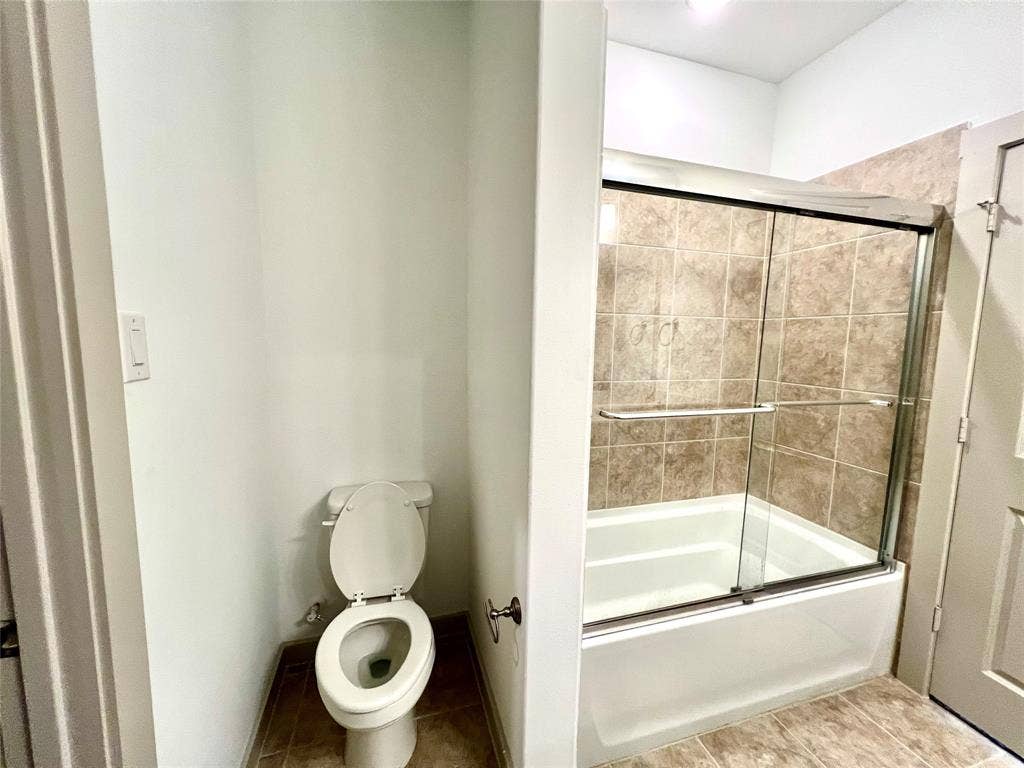 1755 Montgomery Drive, Plano, TX 75075 Bathroom with toilet and bath / shower combo with glass door