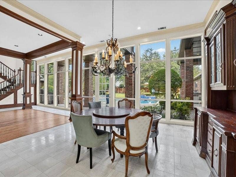 5201 Windjammer Road, Plano, TX 75093 Spacious dining area featuring expansive windows, a decorative chandelier, white tile flooring, and a built-in wooden buffet cabinet