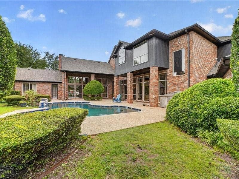 5201 Windjammer Road, Plano, TX 75093 Exterior brick facade with a multi-level design, featuring a built-in swimming pool and a spacious hardscaped patio