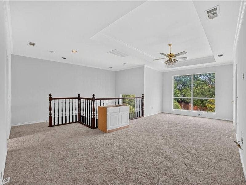 5201 Windjammer Road, Plano, TX 75093 Spacious carpeted room featuring a large window, tray ceiling with fan, recessed lighting, and an open balustrade