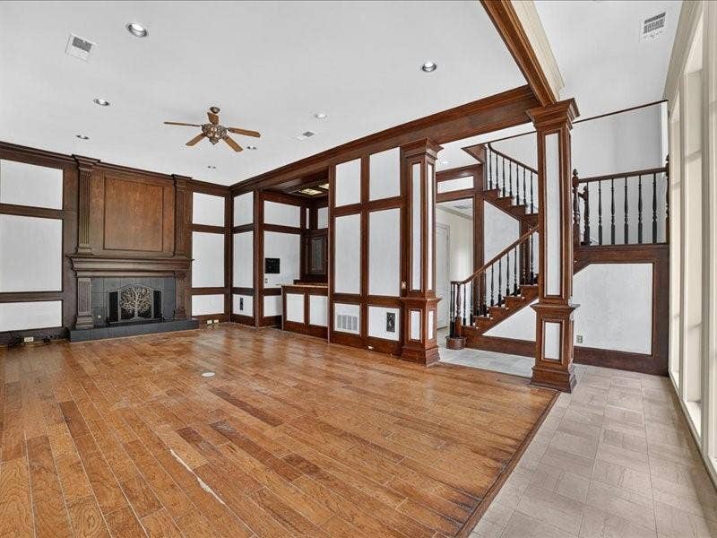 5201 Windjammer Road, Plano, TX 75093 Spacious interior featuring wood-finish flooring, a grand fireplace with an ornate screen, and extensive dark wood paneling