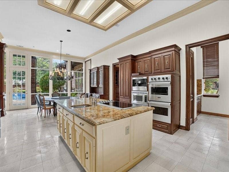5201 Windjammer Road, Plano, TX 75093 Spacious kitchen featuring a large central island with a stone countertop, integrated cooktop, and undermount sink