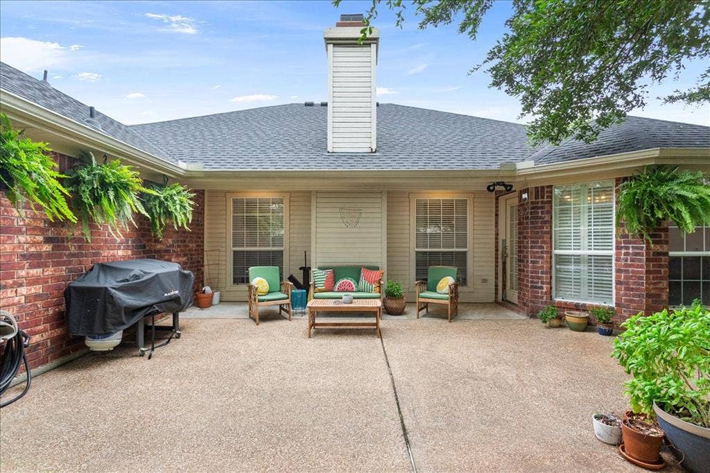 10308 Eagle Mountain Drive, Waco, TX 76712 Spacious L-shaped patio with exposed aggregate concrete flooring, brick exterior walls, multiple windows, and a prominent chimney