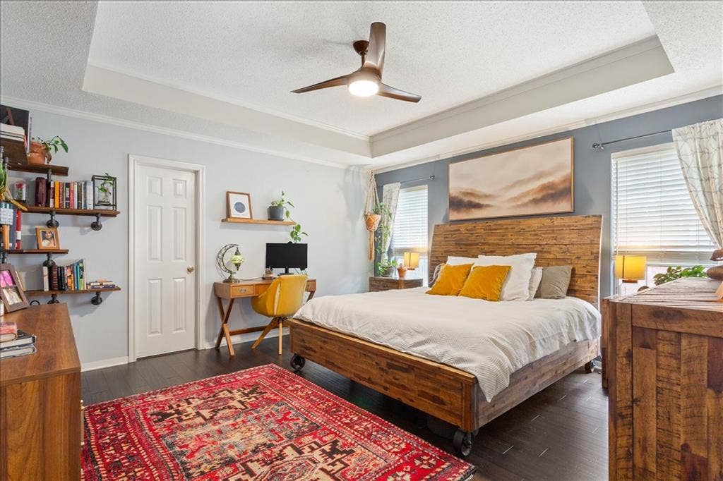 10308 Eagle Mountain Drive, Waco, TX 76712 Bedroom featuring dark wood-finish flooring and a tray ceiling with a ceiling fan