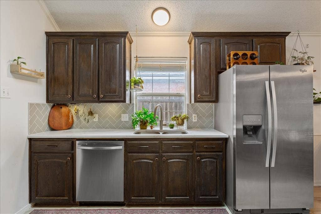 10308 Eagle Mountain Drive, Waco, TX 76712 Kitchen featuring dark wood cabinetry, light countertops, and a herringbone-patterned tile backsplash