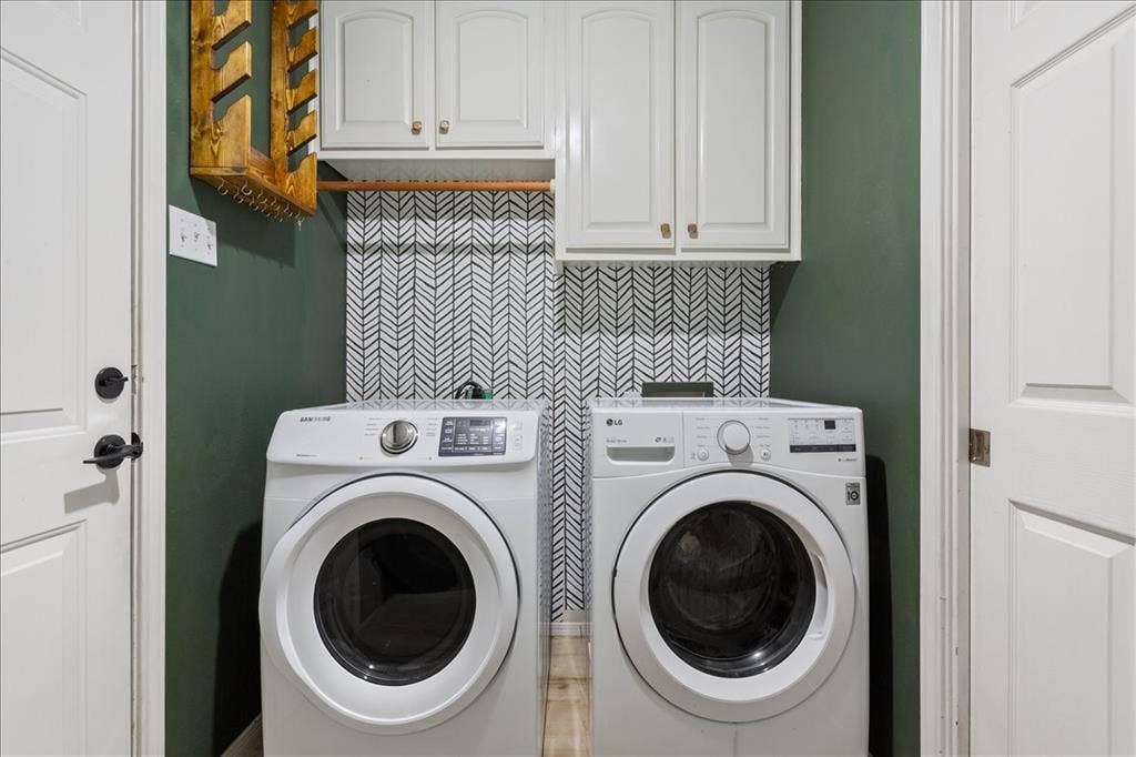10308 Eagle Mountain Drive, Waco, TX 76712 Dedicated laundry area featuring a patterned backsplash, overhead cabinetry with brass-finish hardware, a wooden hanging rod, and contrasting accent wall