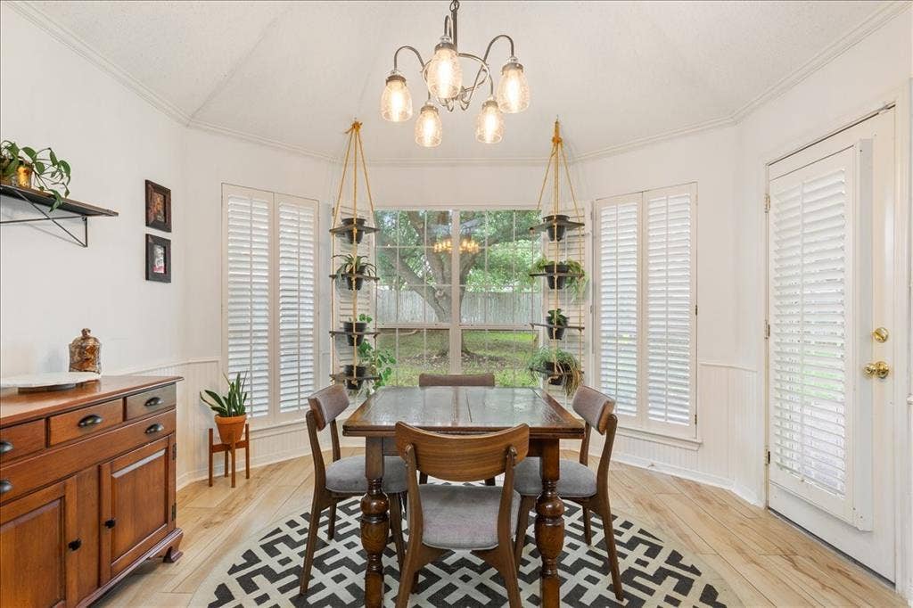 10308 Eagle Mountain Drive, Waco, TX 76712 Tray ceiling with a five-light chandelier, wood-finish flooring, white paneling, and an exterior door with louvered blinds