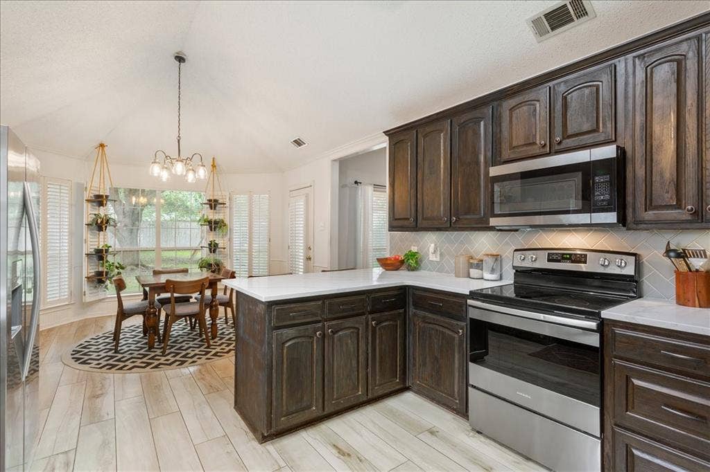 10308 Eagle Mountain Drive, Waco, TX 76712 Kitchen featuring dark wood cabinetry, light countertops, and stainless steel appliances