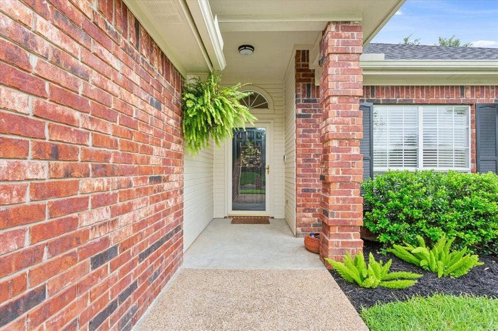 10308 Eagle Mountain Drive, Waco, TX 76712 Brick exterior with covered entryway, arched transom window, and a concrete pathway