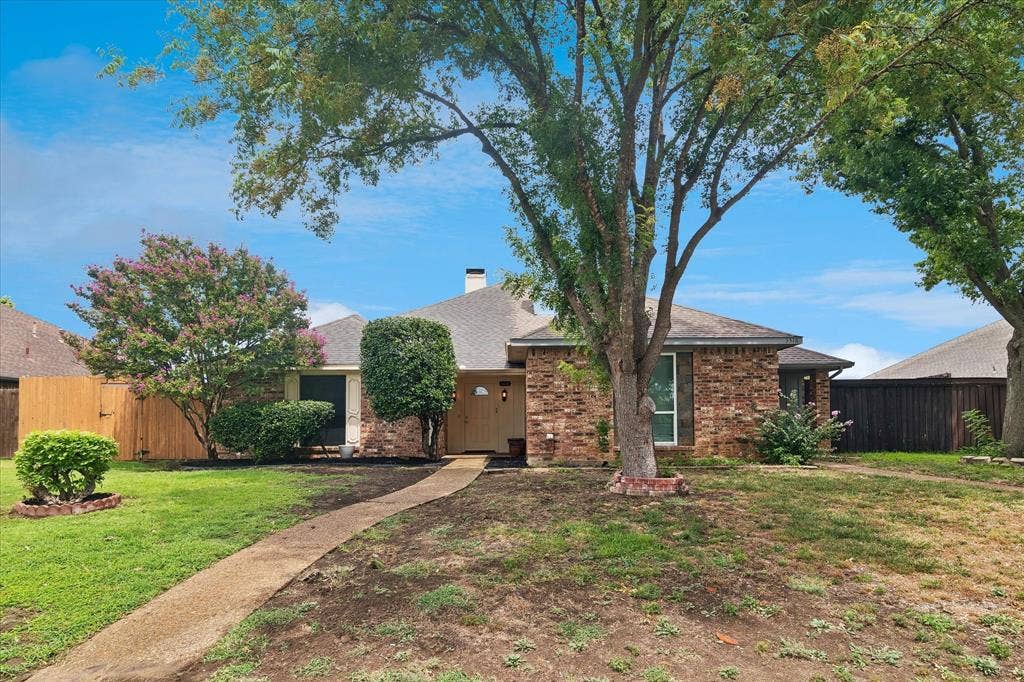 3318 Wells Drive, Plano, TX 75093 Brick exterior featuring a gabled roof and a concrete walkway
