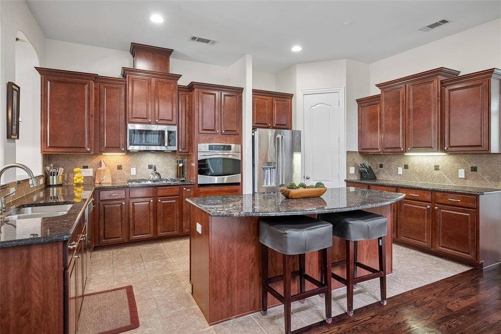 Accent lighting, plenty of prep space, and a gas cooktop are some of the features of the kitchen to enjoy.