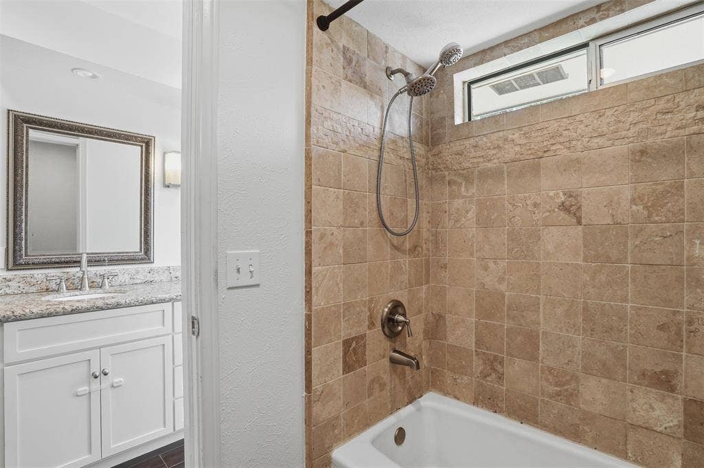 1000 Lexington Drive, Plano, TX 75075 Tiled shower surround with a dual-head shower fixture and an upper transom window
