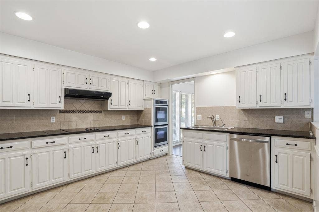 1000 Lexington Drive, Plano, TX 75075 Kitchen featuring white cabinetry with dark hardware, dark countertops, and tile flooring