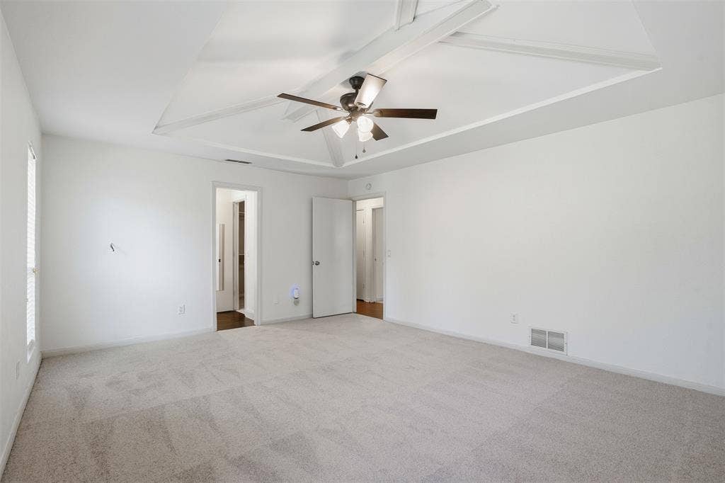 1000 Lexington Drive, Plano, TX 75075 Spacious room featuring a decorative tray ceiling with exposed white beams and a ceiling fan