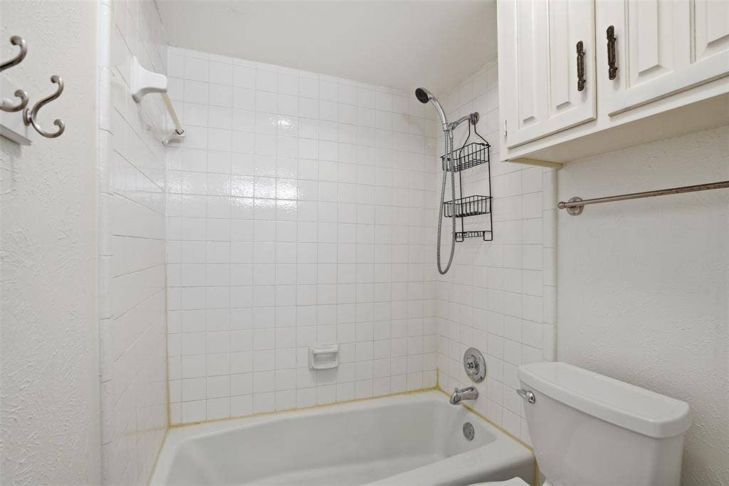 1000 Lexington Drive, Plano, TX 75075 White tile shower surround with a fixed bathtub