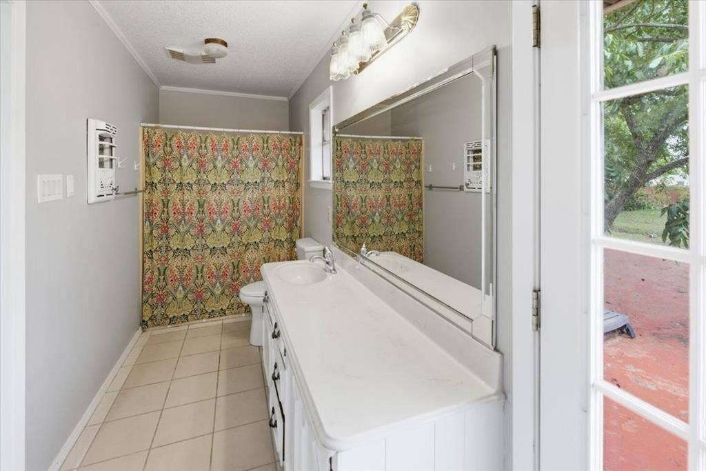 612 W Highland Street, West, TX 76691 Primary ensuite bathroom featuring a separate vanities with integrated sinks, a combination tub & shower, tile flooring, and access to the back patio