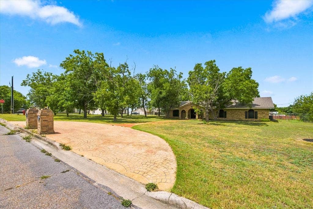 612 W Highland Street, West, TX 76691 Circle drive and walkway providing access to the front entrance. Large lot of approximately 0.75 acres.