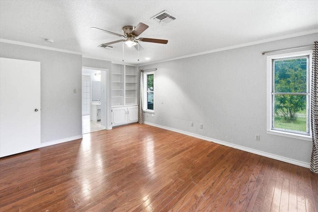 612 W Highland Street, West, TX 76691 Primary bedroom with ceiling fan, built-in shelving, and an ensuite bath