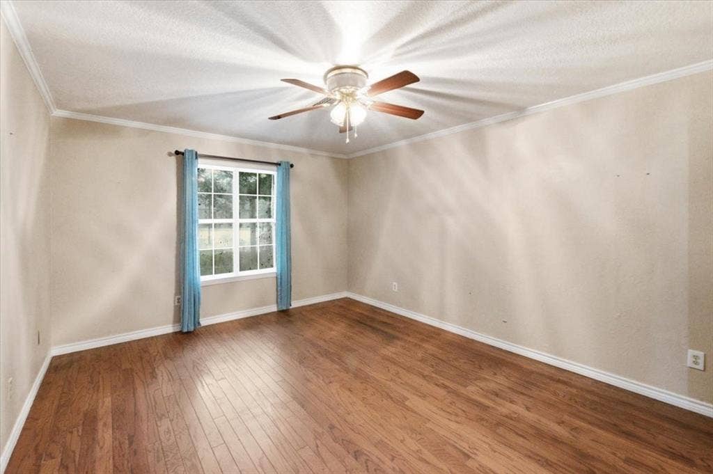 612 W Highland Street, West, TX 76691 Spacious room featuring wood-finish flooring, a ceiling fan, neutral wall tones, and white crown molding. Used by the current owners as a formal dining room