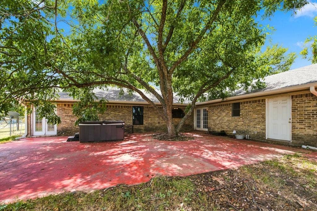612 W Highland Street, West, TX 76691 Large back porch area with an amazing shade tree. Exits from the primary bathroom, kitchen area, and utility room