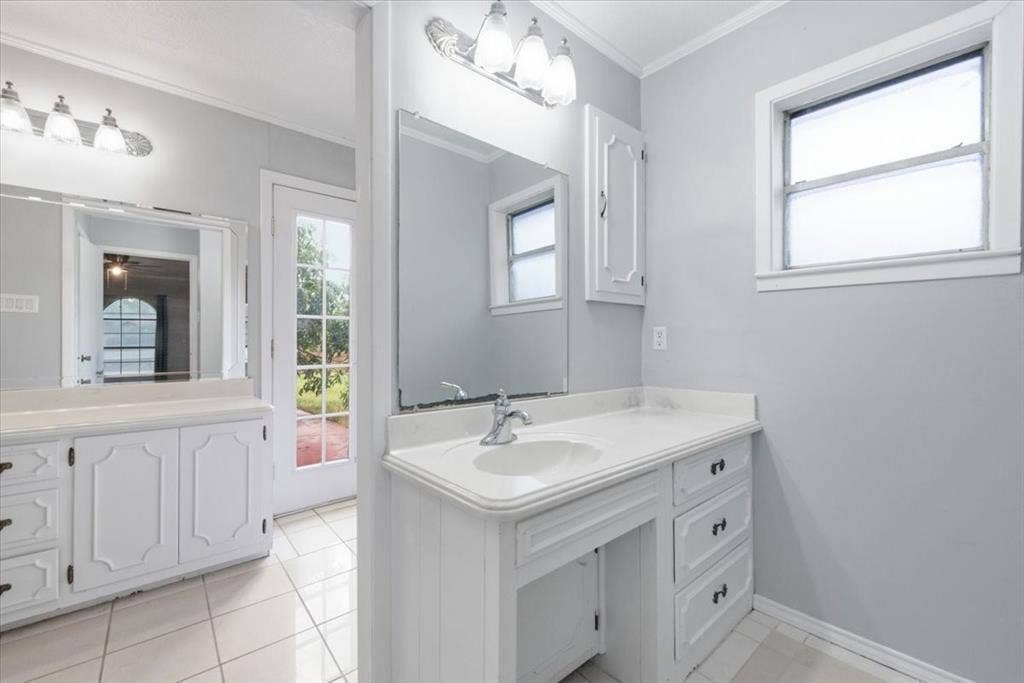 612 W Highland Street, West, TX 76691 Bathroom vanity featuring a separate vanities with sinks, ample countertop space, and integrated storage cabinetry, and an exit to the back patio