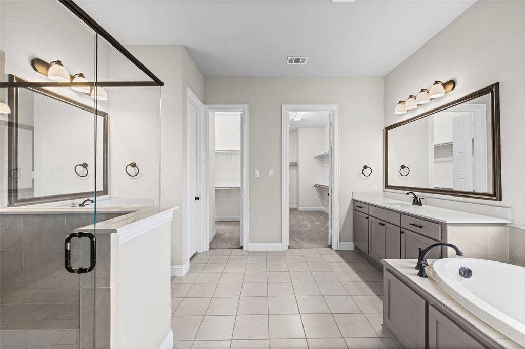 3200 Tail Water Drive, Mansfield, TX 76063 Massive primary bathroom has separate vanities, shower, garden tub, and two huge closets, one that connects to the laundry room