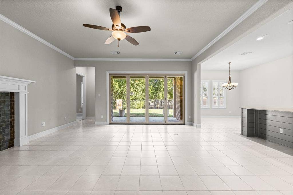 3200 Tail Water Drive, Mansfield, TX 76063 Large living room with fireplace and sliding glass doors to the covered patio
