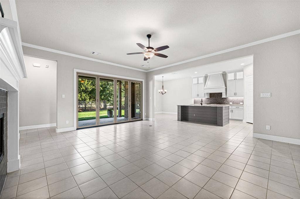 3200 Tail Water Drive, Mansfield, TX 76063 Large living room with fireplace and sliding glass doors to the covered patio. Open to the kitchen