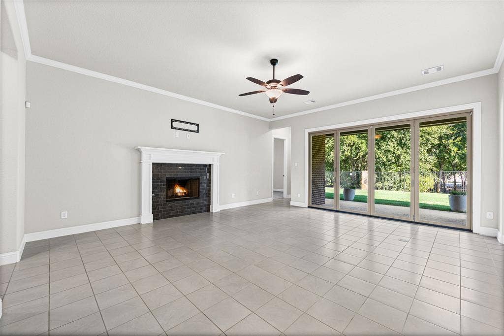 3200 Tail Water Drive, Mansfield, TX 76063 Large living room with fireplace and sliding glass doors to the covered patio