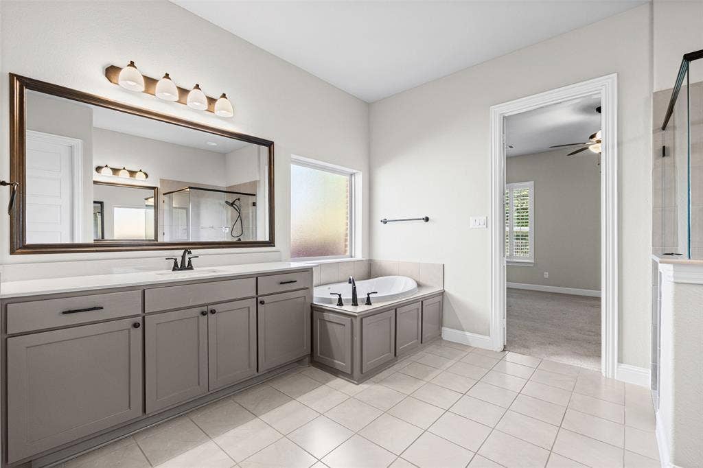 3200 Tail Water Drive, Mansfield, TX 76063 Massive primary bathroom has separate vanities, shower, garden tub, and two huge closets, one that connects to the laundry room
