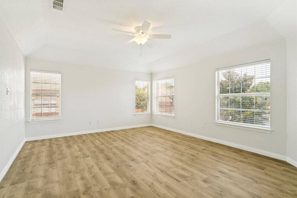 8512 Mesa Verde Drive, Plano, TX 75025 Spacious room featuring wood-finish flooring, vaulted ceiling, and a ceiling fan with light fixture