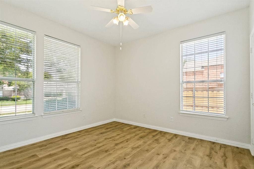 8512 Mesa Verde Drive, Plano, TX 75025 Room featuring wood-finish flooring, white baseboards, and neutral wall paint