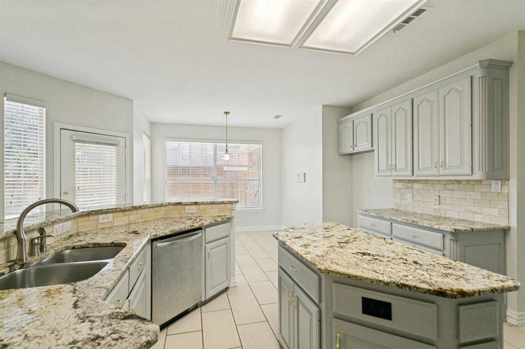 8512 Mesa Verde Drive, Plano, TX 75025 Kitchen featuring light-toned cabinetry, granite countertops, tile flooring, and a subway tile backsplash