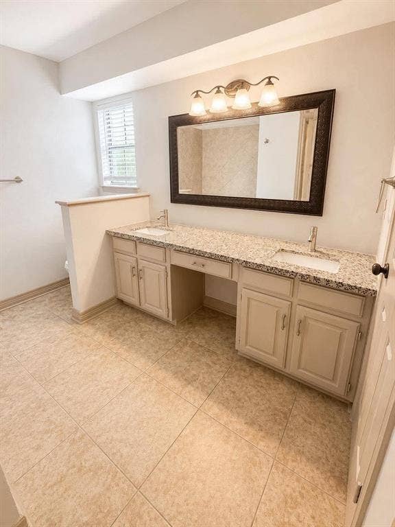 7806 Williams Avenue, Frisco, TX 75033 Bathroom featuring an expansive dual vanity with integrated sinks, granite-finish countertop, and light-toned cabinetry