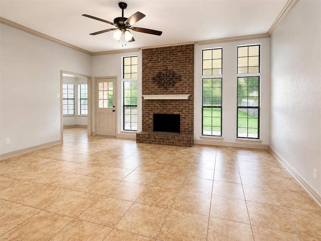 7806 Williams Avenue, Frisco, TX 75033 Living space featuring a brick fireplace with a white mantel, ceiling fan, and large tile flooring