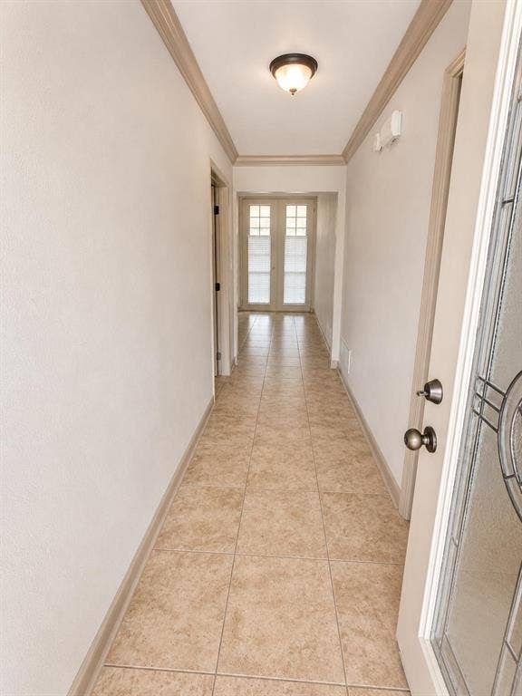 7806 Williams Avenue, Frisco, TX 75033 Entry hall featuring neutral-toned ceramic tile flooring, crown molding, and a flush-mount ceiling light