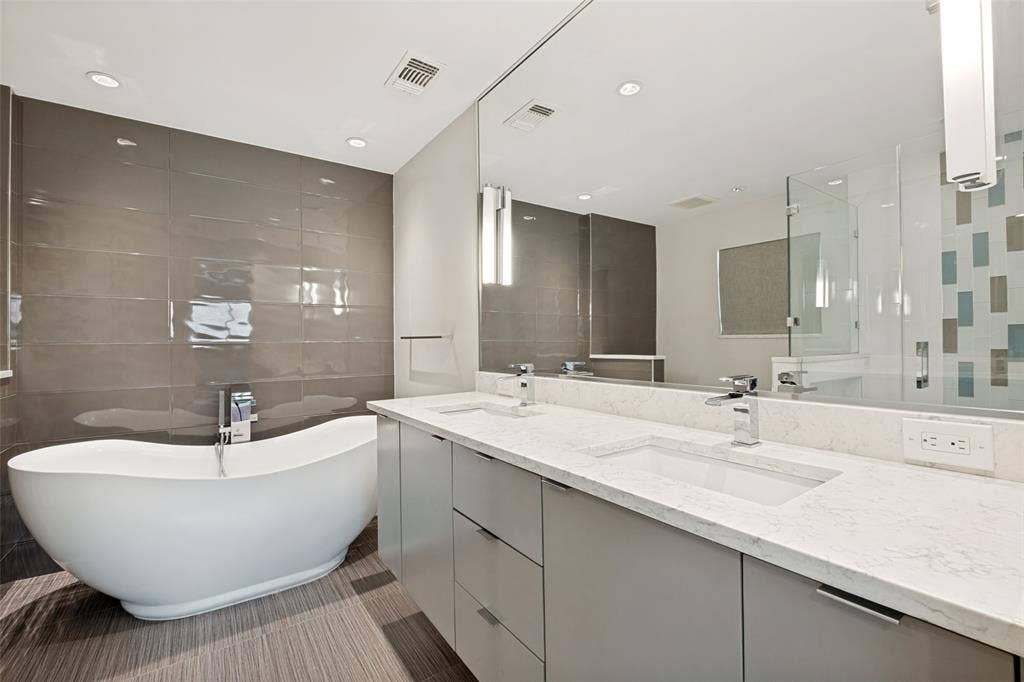 12022 Dixfield Drive, Dallas, TX 75218 Updated primary bathroom featuring a relaxing soaking tub and double sinks.