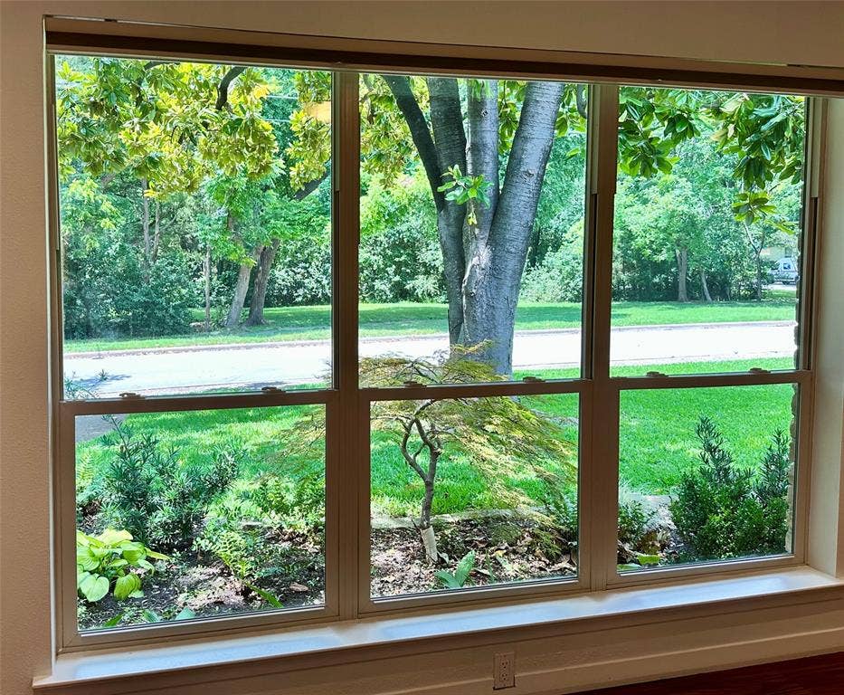 12022 Dixfield Drive, Dallas, TX 75218 Front living space with peaceful views of the surrounding green space.