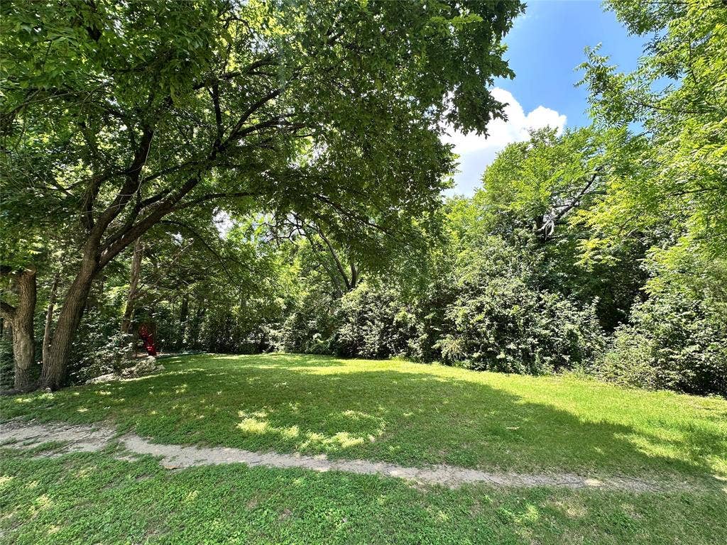 12022 Dixfield Drive, Dallas, TX 75218 A beautiful stretch of green space across the street enhances the home’s inviting surroundings.