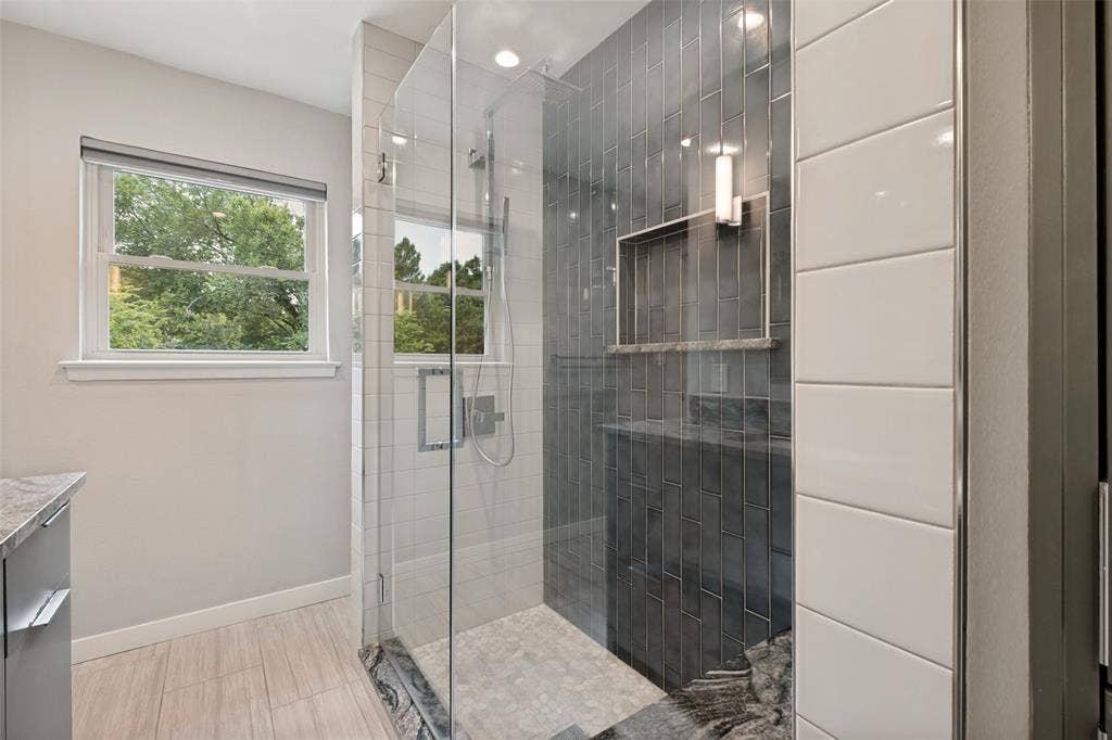 12022 Dixfield Drive, Dallas, TX 75218 Updated upstairs bathroom featuring a modern shower and stylish finishes.