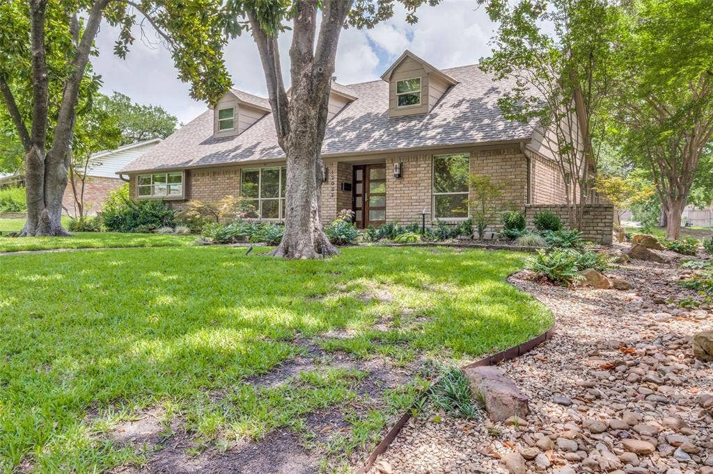 12022 Dixfield Drive, Dallas, TX 75218 Front yard framed by large magnolia trees and established greenery.