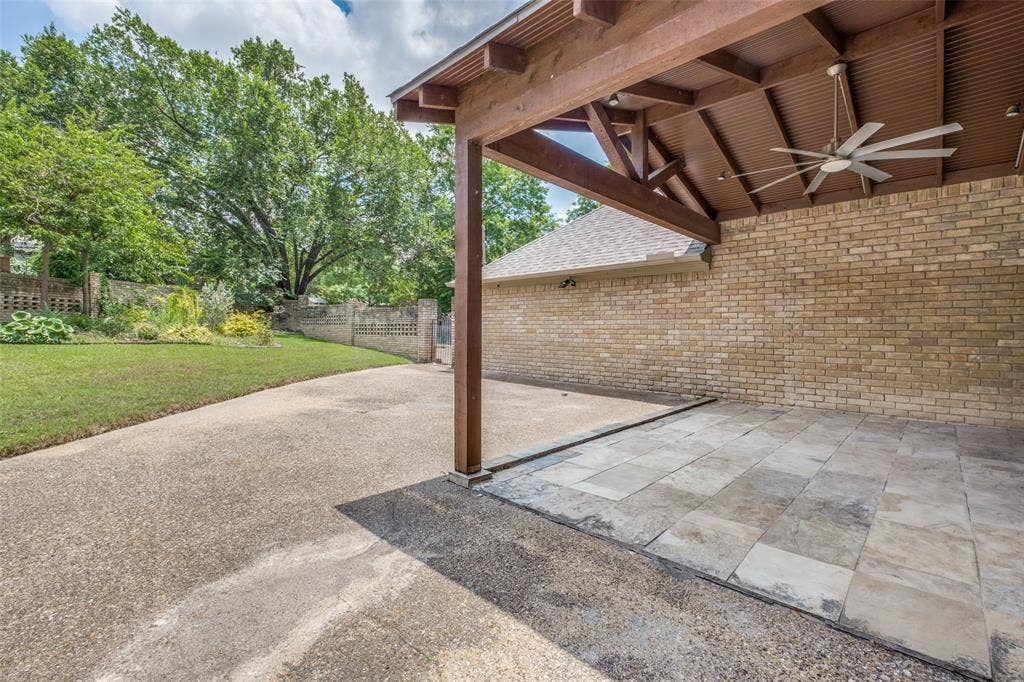 12022 Dixfield Drive, Dallas, TX 75218 Large covered patio featuring a ceiling fan and television, creating a comfortable space for relaxing or entertaining outdoors.