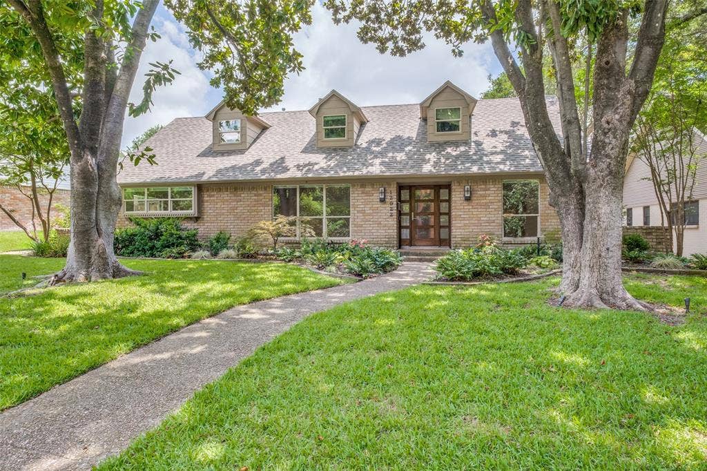 12022 Dixfield Drive, Dallas, TX 75218 Large front yard with mature trees and lush landscaping.
