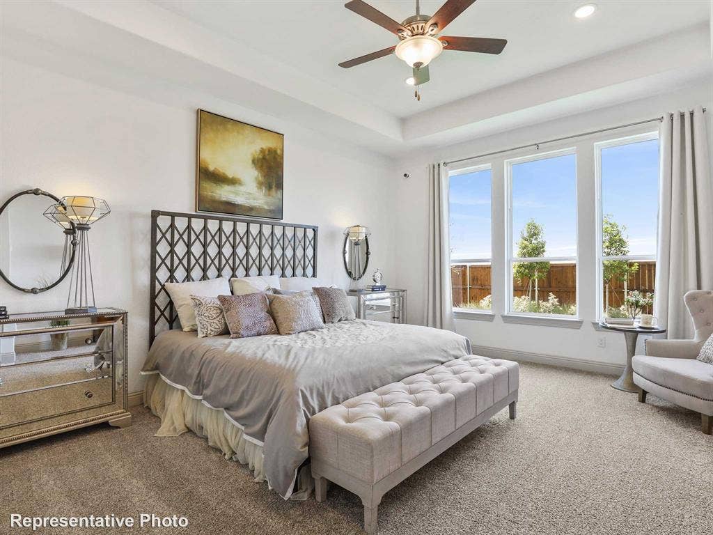 4359 Michigan Avenue, Midlothian, TX 76065 Carpeted room featuring a tray ceiling with a ceiling fan, a large window array, and a dark metal headboard