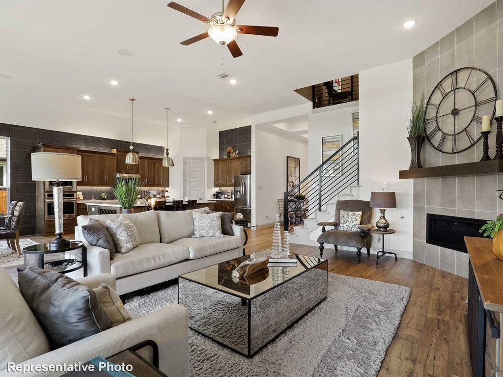 4359 Michigan Avenue, Midlothian, TX 76065 Spacious living area featuring wood-finish flooring, a tiled fireplace with a wood mantel, and an open-concept design