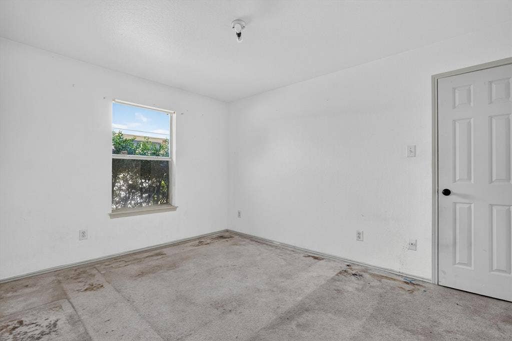 1414 Aviary Drive, DeSoto, TX 75115 Windowed interior space with a paneled door and exposed concrete flooring