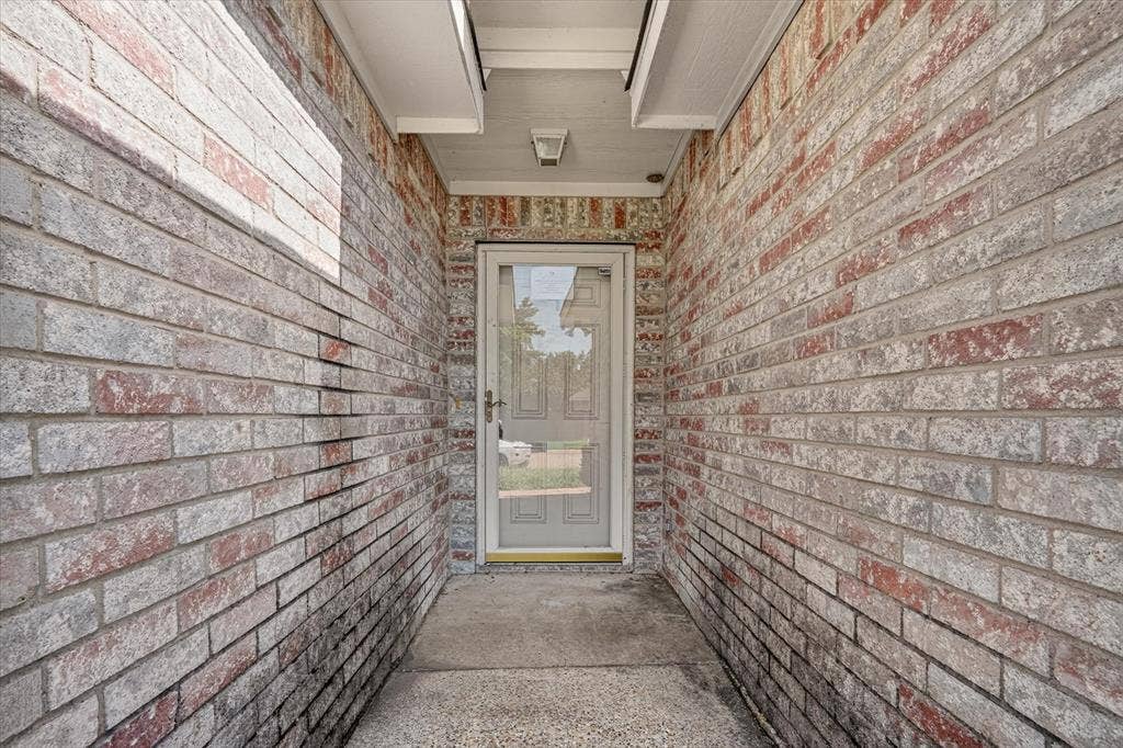 1414 Aviary Drive, DeSoto, TX 75115 Entryway featuring mixed-tone brick siding and a storm door
