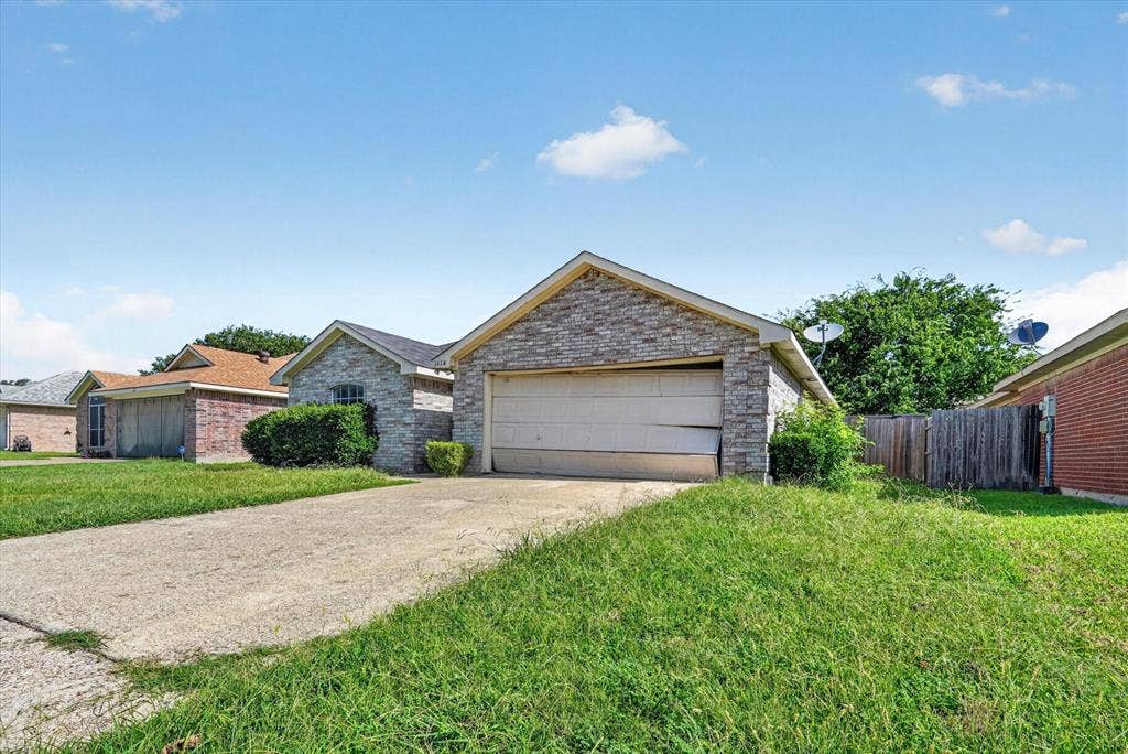 1414 Aviary Drive, DeSoto, TX 75115 Stone veneer facade with an integrated single-car garage and concrete driveway
