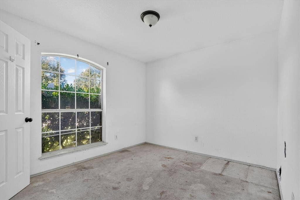 1414 Aviary Drive, DeSoto, TX 75115 Room featuring a large arched window with multiple panes, white walls, and a ceiling-mounted light fixture